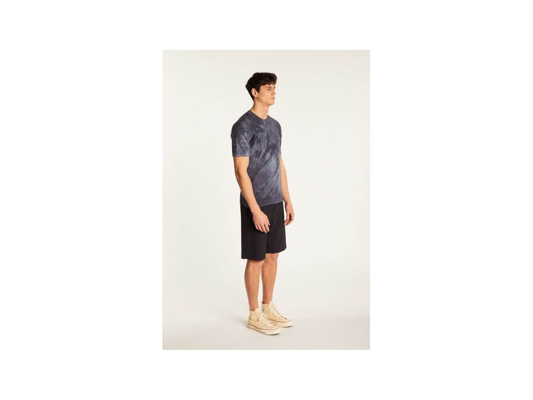 Model displaying the Marquez T-Shirt in a stylish tie-dye pattern, paired with shorts for a casual look.