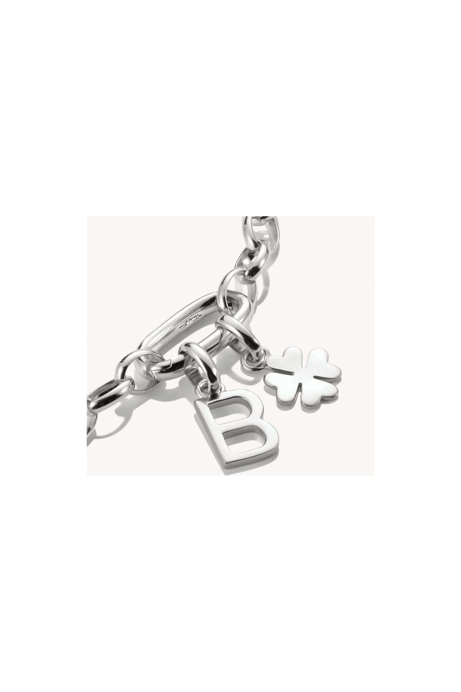 Pendentif charm argent en forme de lettre 'B' et symbole floral sur bracelet en argent recyclé