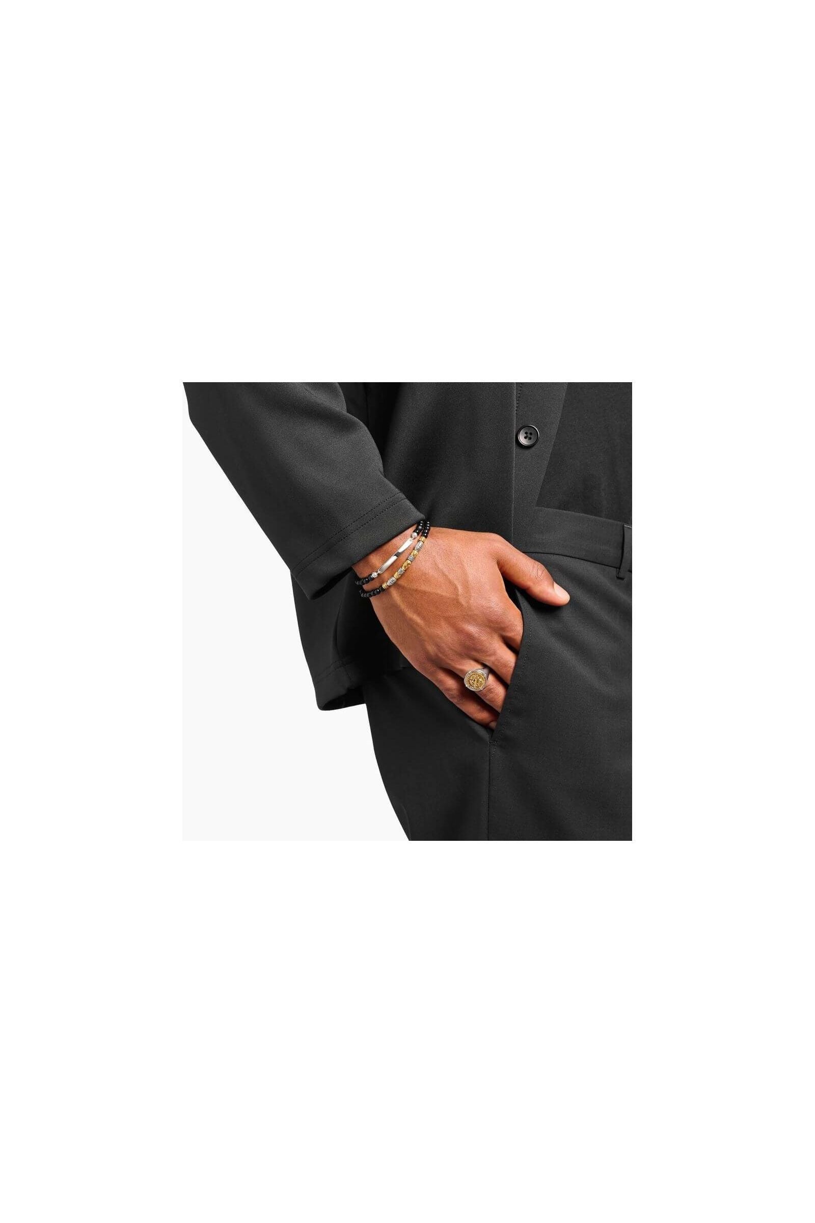 Homme portant un bracelet à graver en obsidienne avec un costume élégant, ajoutant une touche de sophistication.