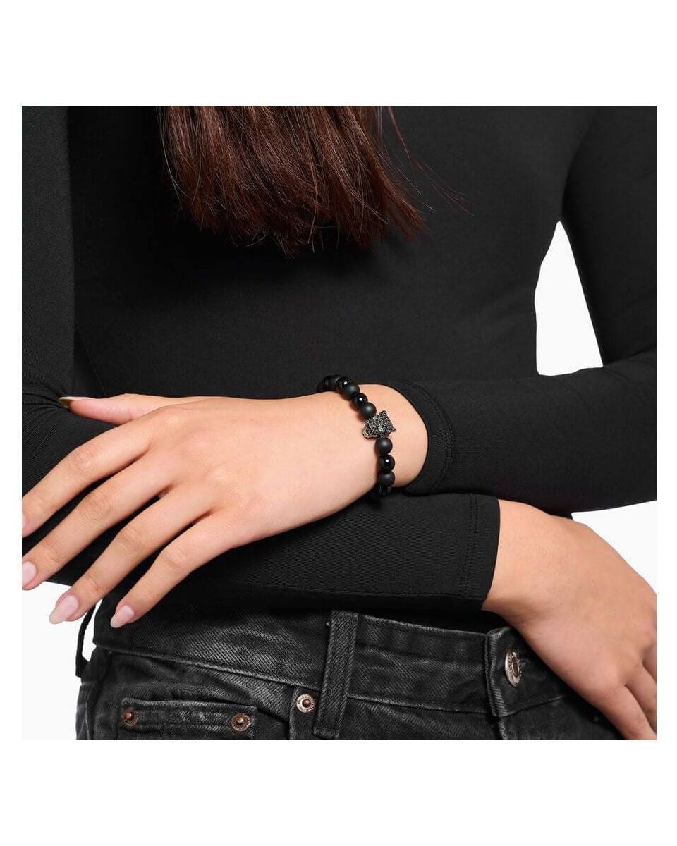 Bracelet en obsidienne avec perle en forme de chat noir, porté sur un bras, style élégant et raffiné.