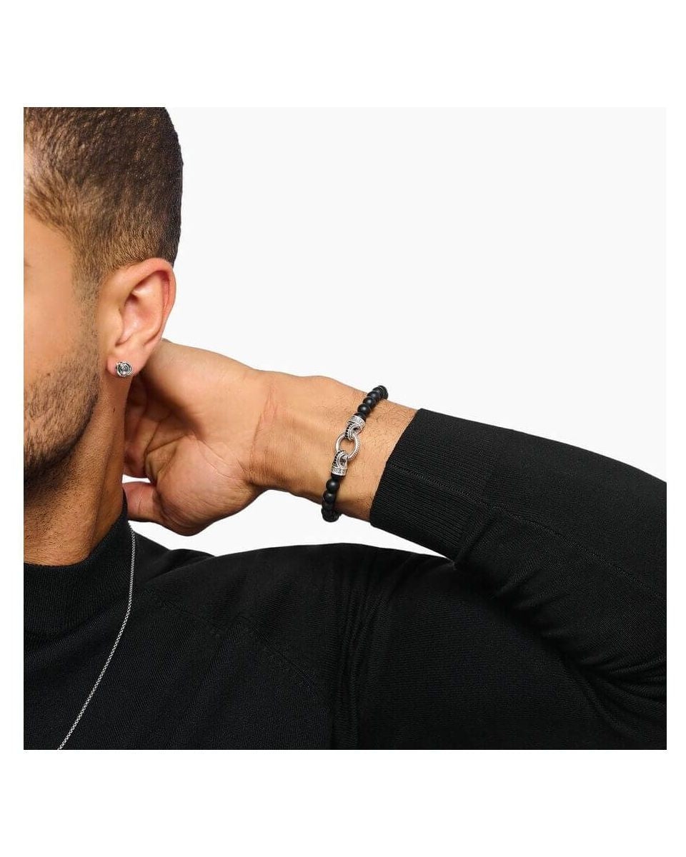 Homme portant un bracelet en beads d'obsidienne noire et argent, mettant en valeur l'élégance et la sophistication.