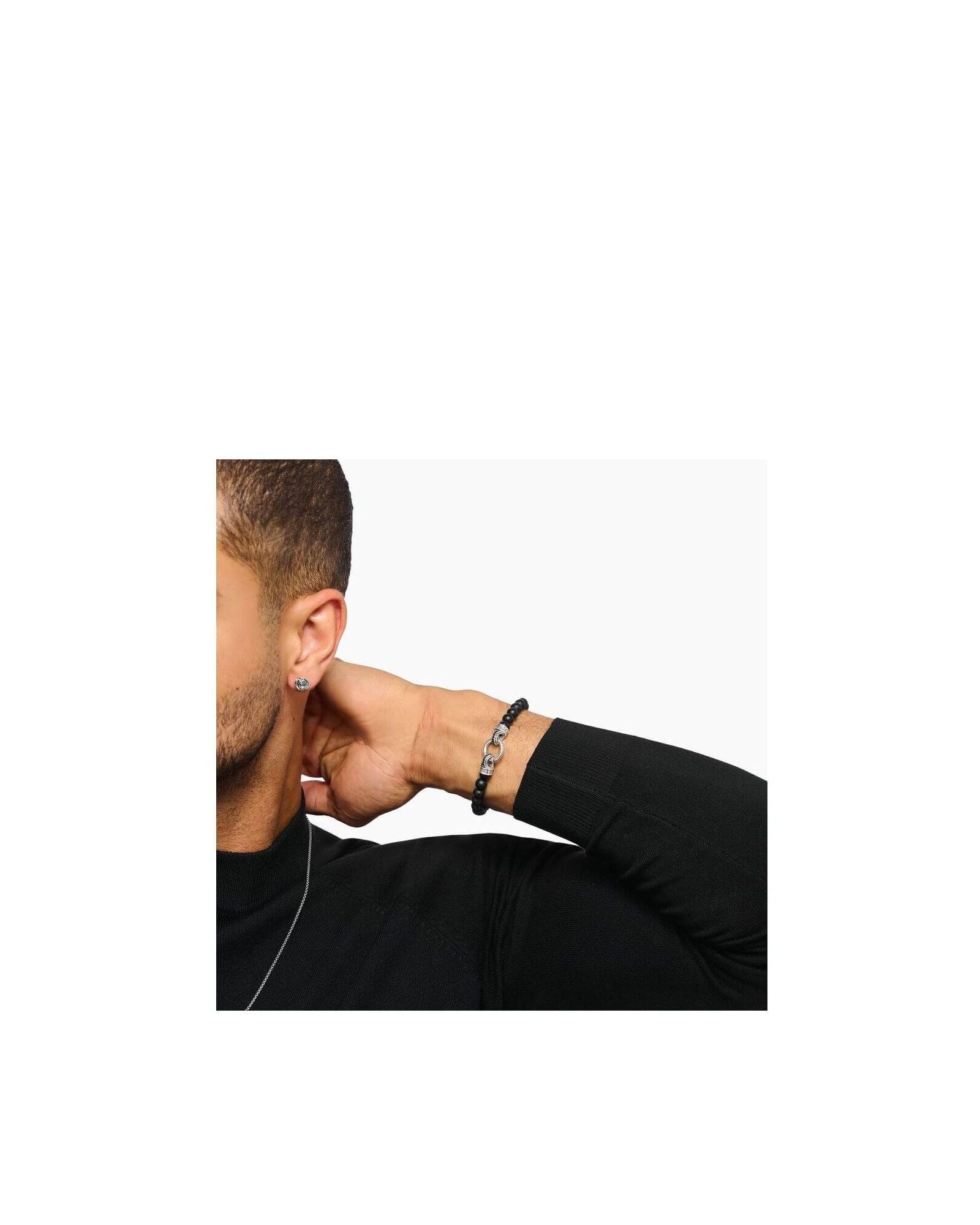 Homme portant un bracelet en beads d'obsidienne noire et argent, mettant en valeur l'élégance et la sophistication.