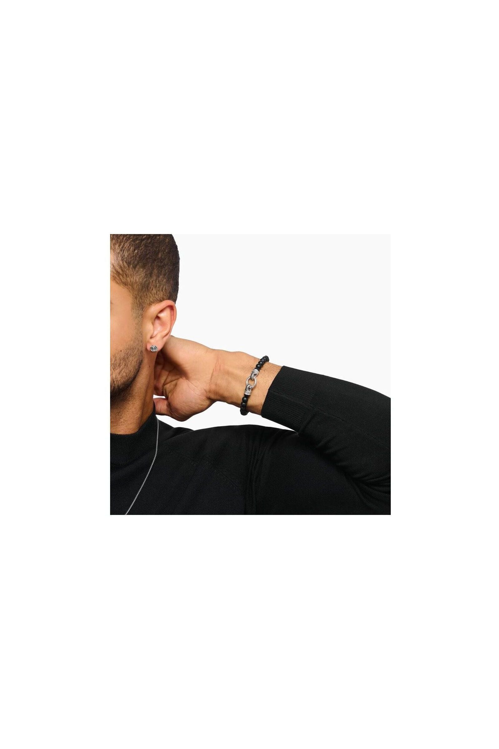 Homme portant un bracelet en beads d'obsidienne noire et argent, mettant en valeur l'élégance et la sophistication.