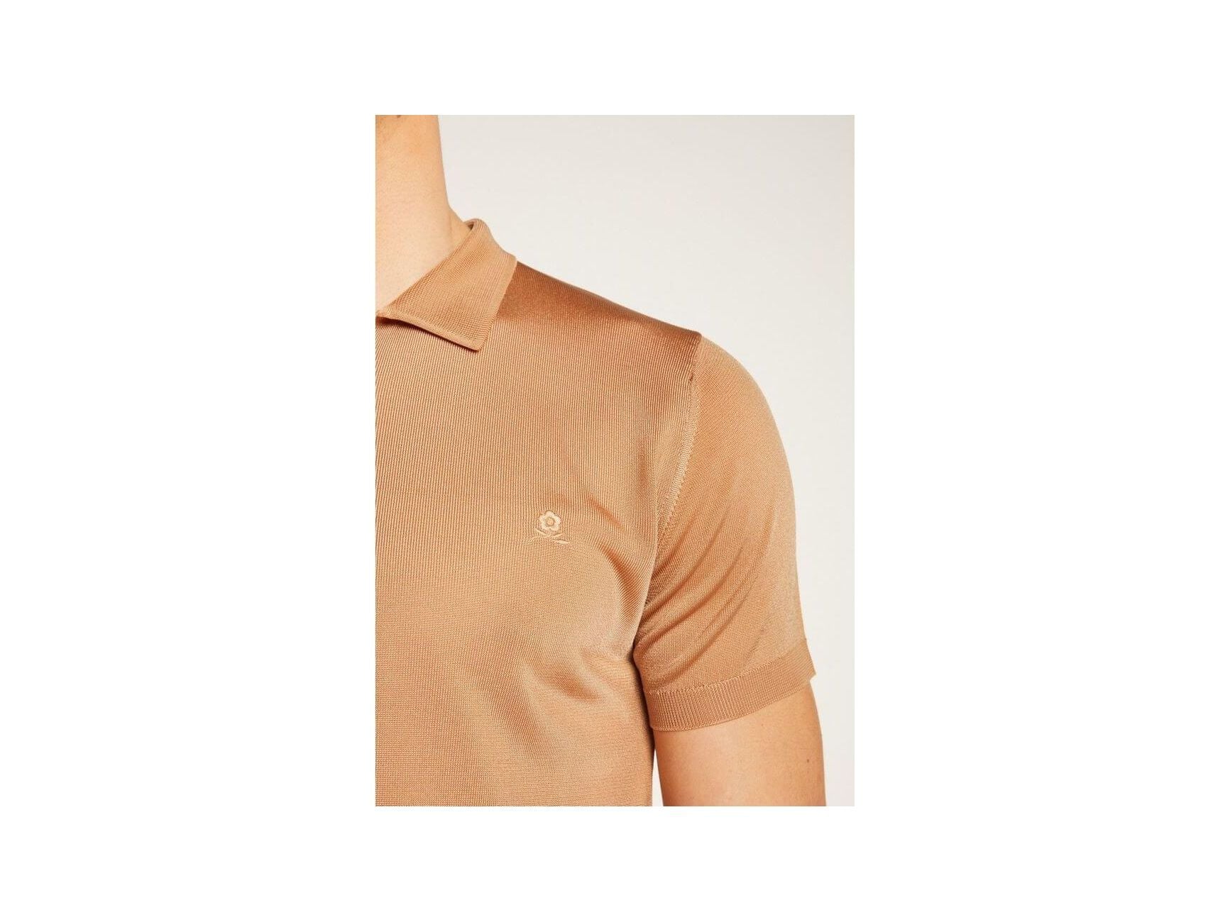 Close-up of a tan short-sleeve polo shirt made of Fil lumière fabric, showcasing its elegant texture.