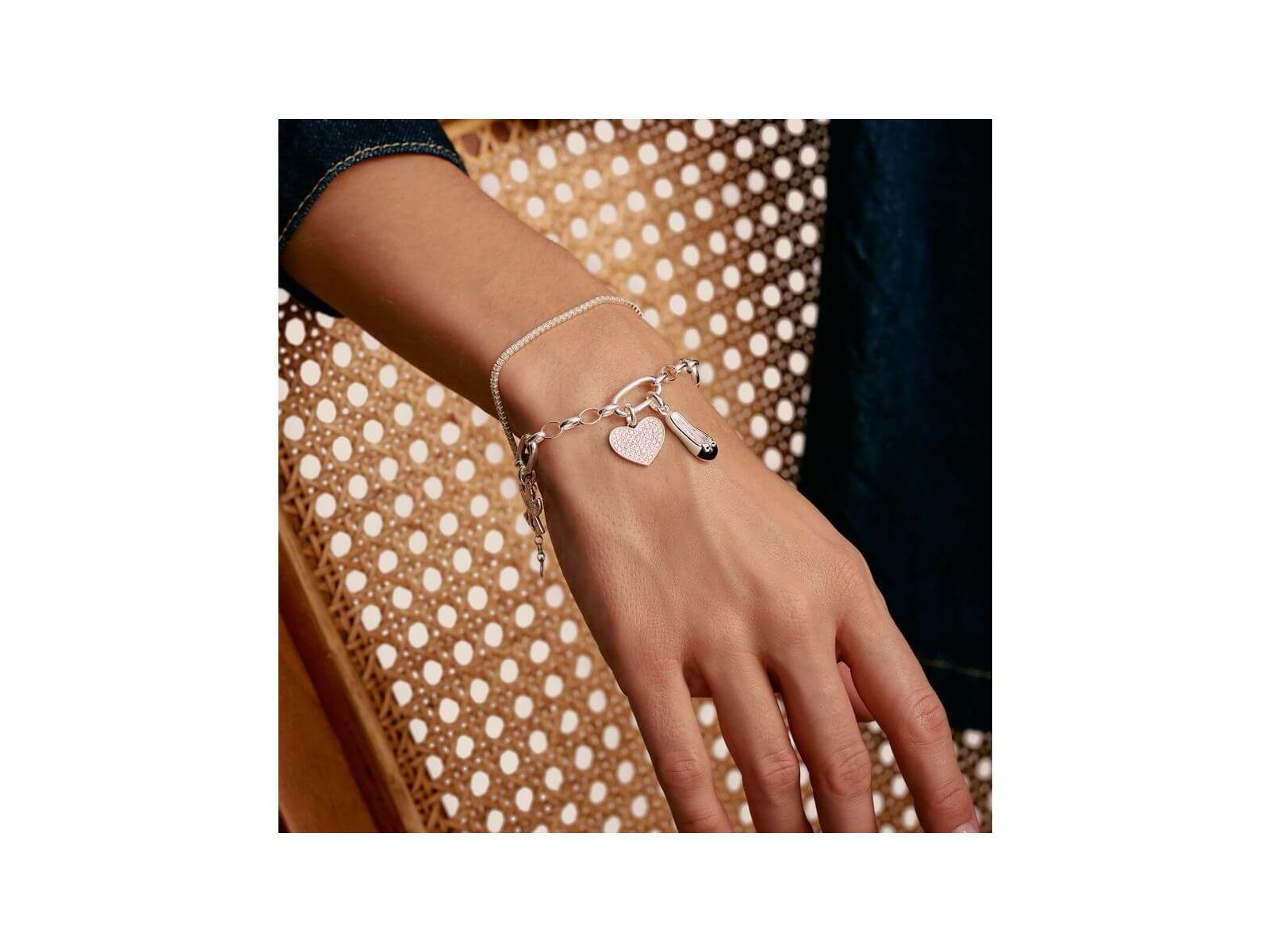 Bracelet charm en argent avec lien connect, cœur et breloque, élégant et personnalisable, porté sur un poignet.