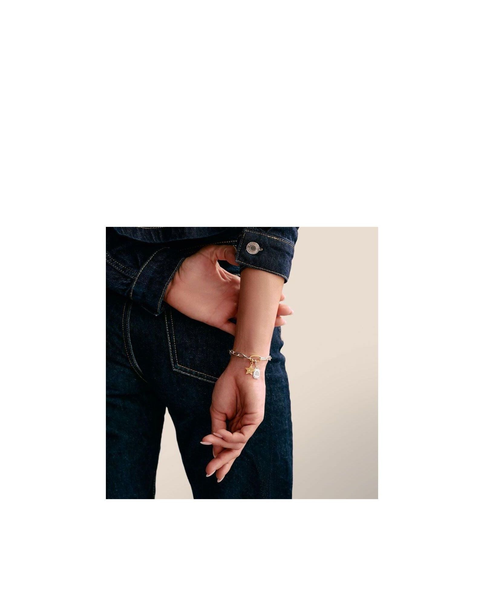 Bracelet with star charm and white stone, showcasing elegance and style on a woman's wrist.
