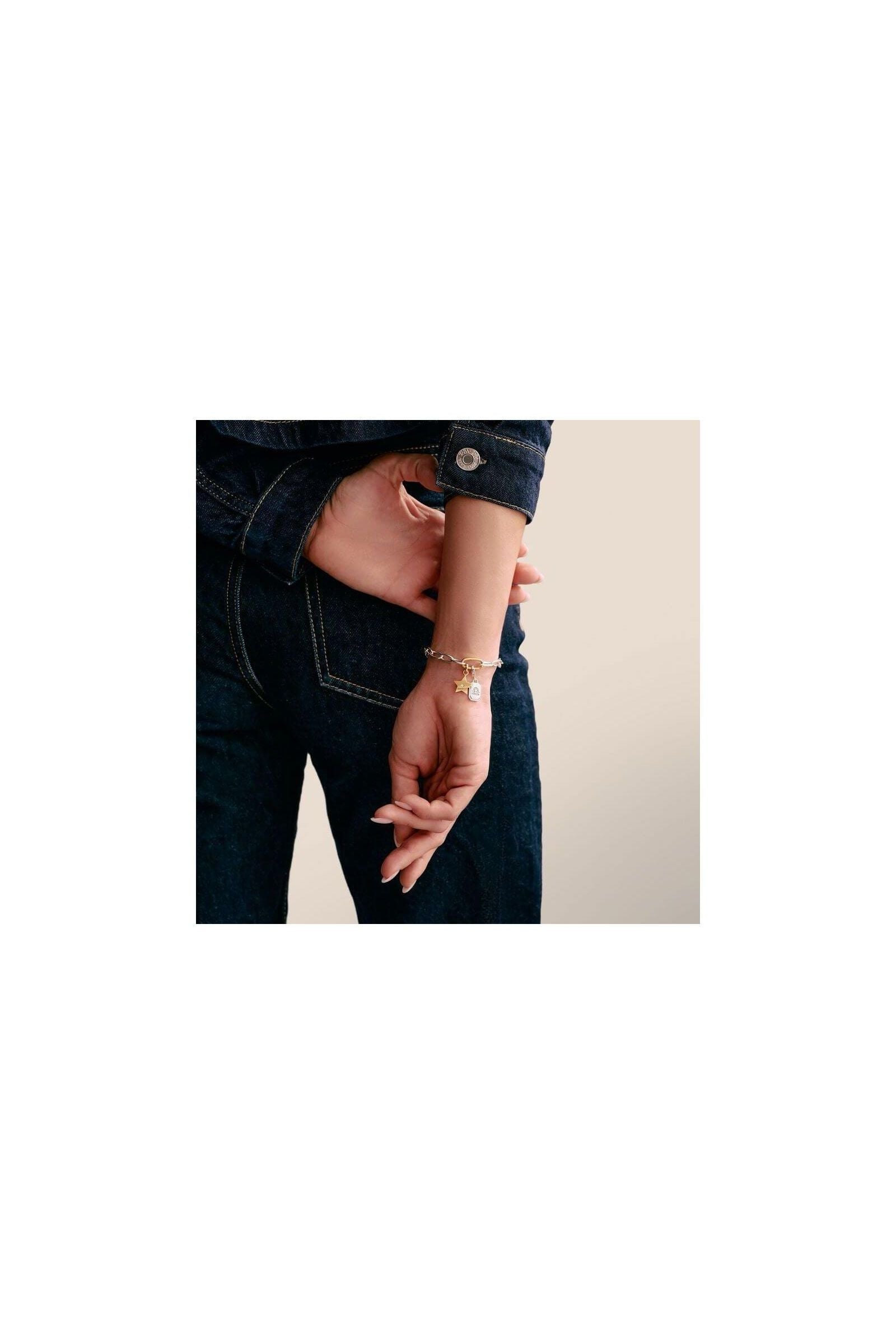 Bracelet with star charm and white stone, showcasing elegance and style on a woman's wrist.