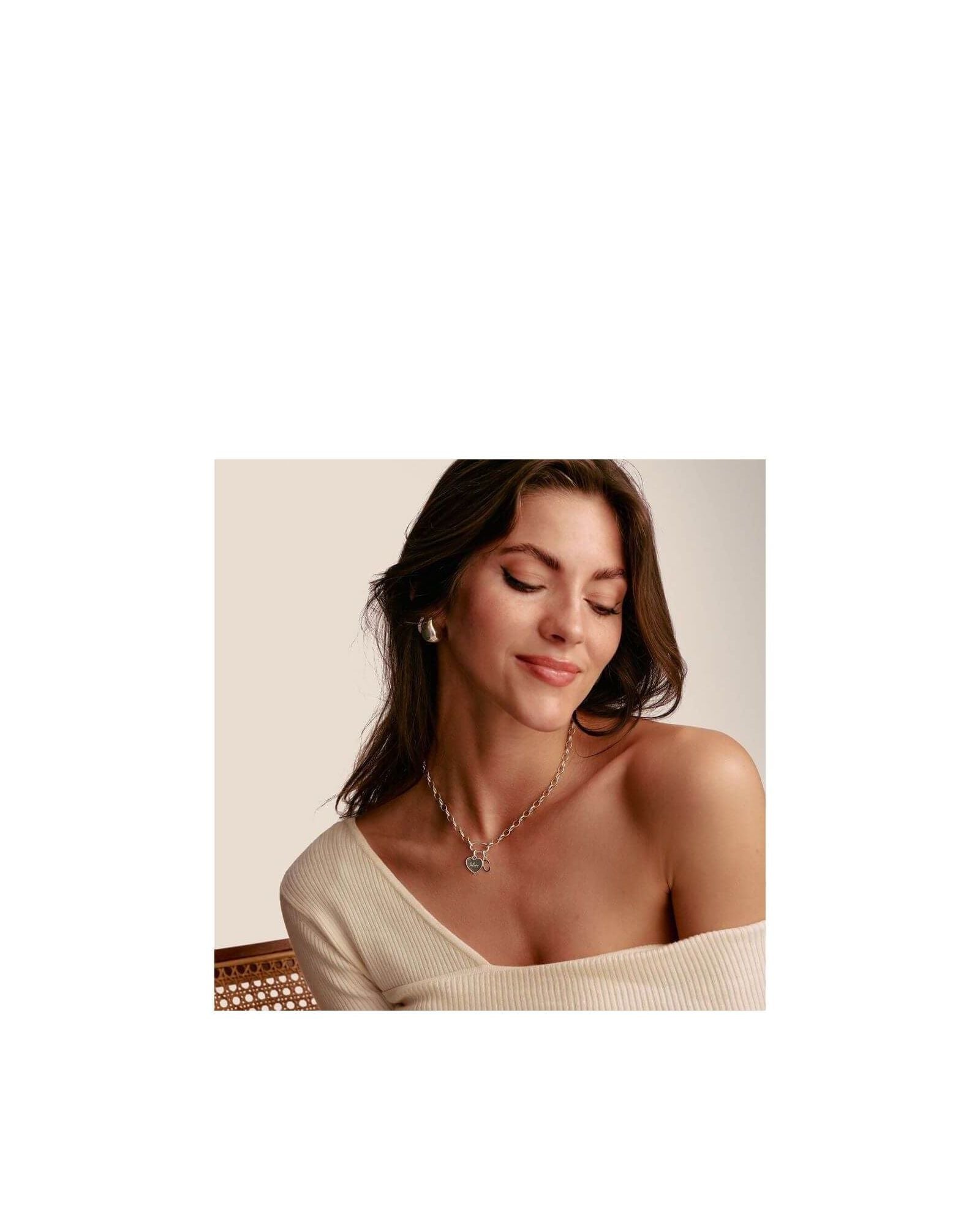 Femme portant un pendentif charm cœur en argent, affichant un style élégant et minimaliste.