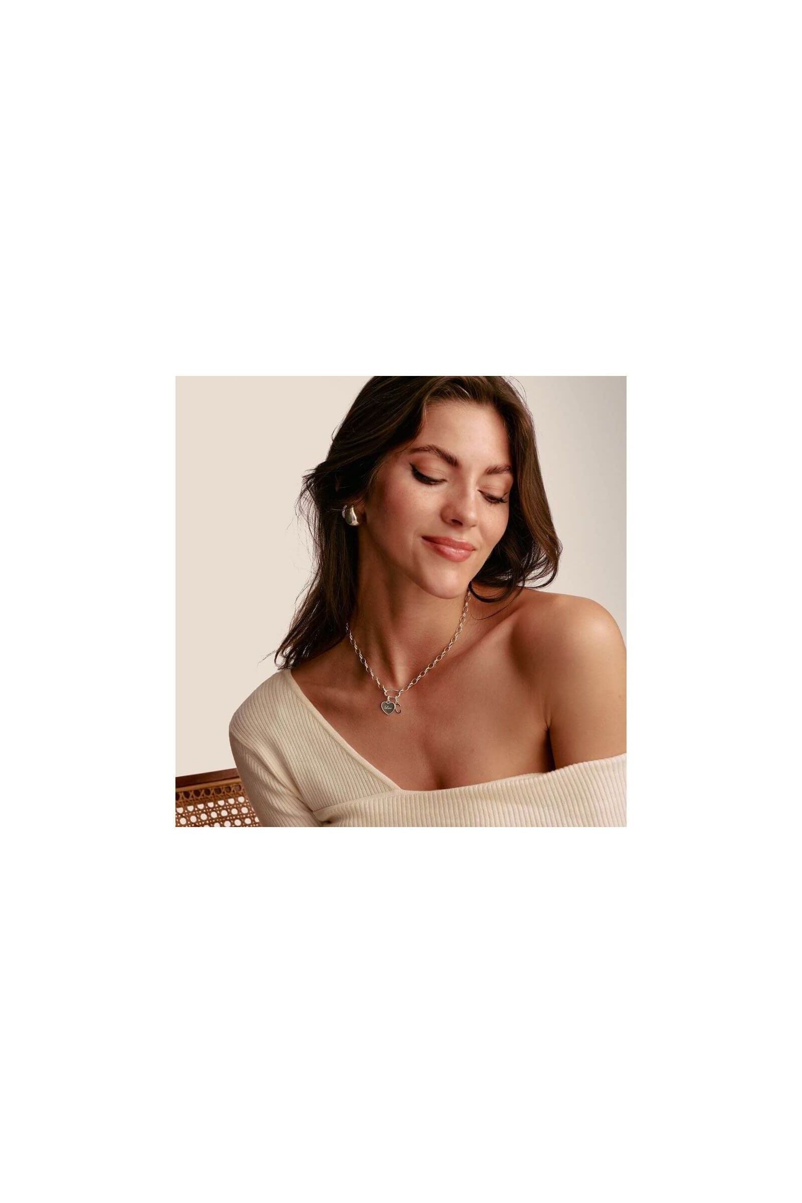 Femme portant un pendentif charm cœur en argent, affichant un style élégant et minimaliste.
