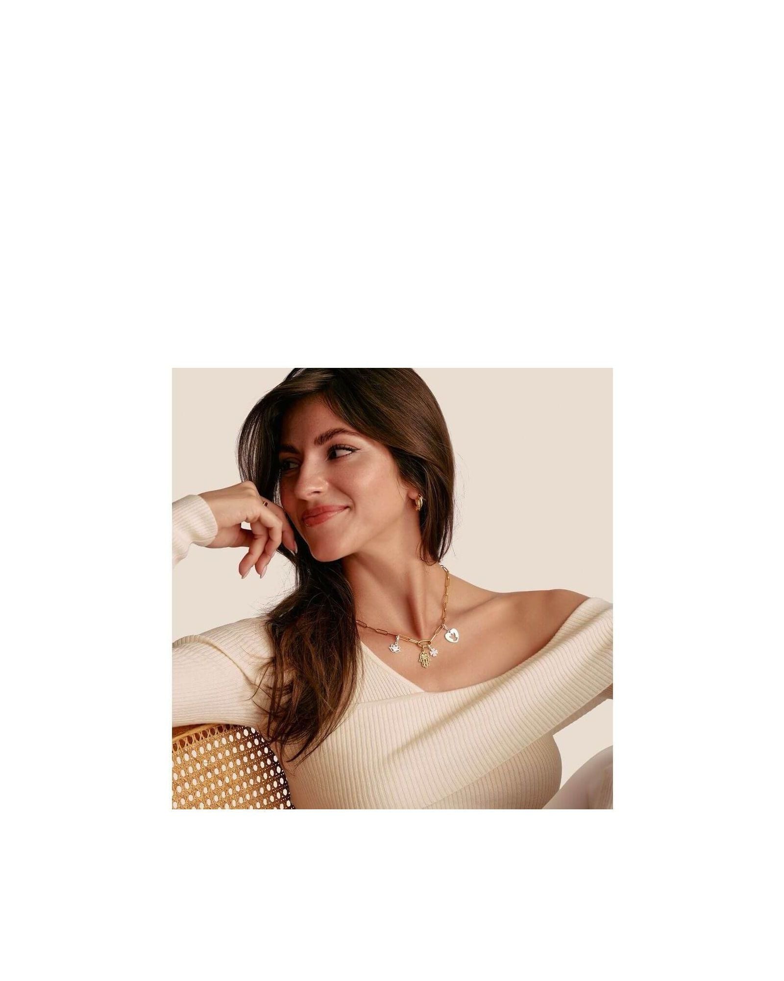 Femme souriante portant un collier élégant avec pendentifs en forme de main Hamsa en or plaqué.