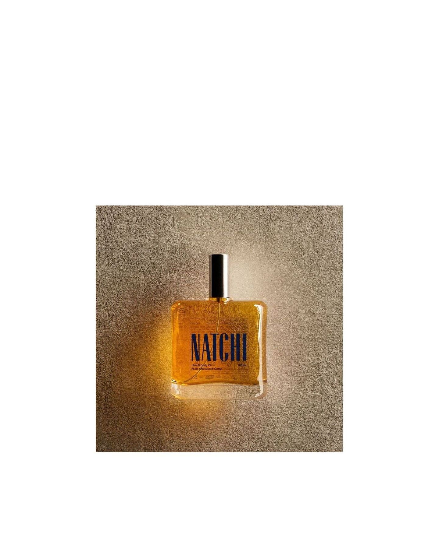 NATCHI Organic Hair & Body Oil bottle against a textured background, showcasing its natural ingredients and elegant design.