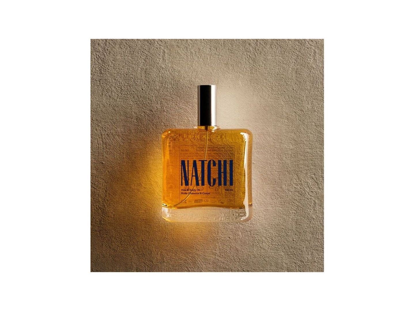 NATCHI Organic Hair & Body Oil bottle against a textured background, showcasing its natural ingredients and elegant design.