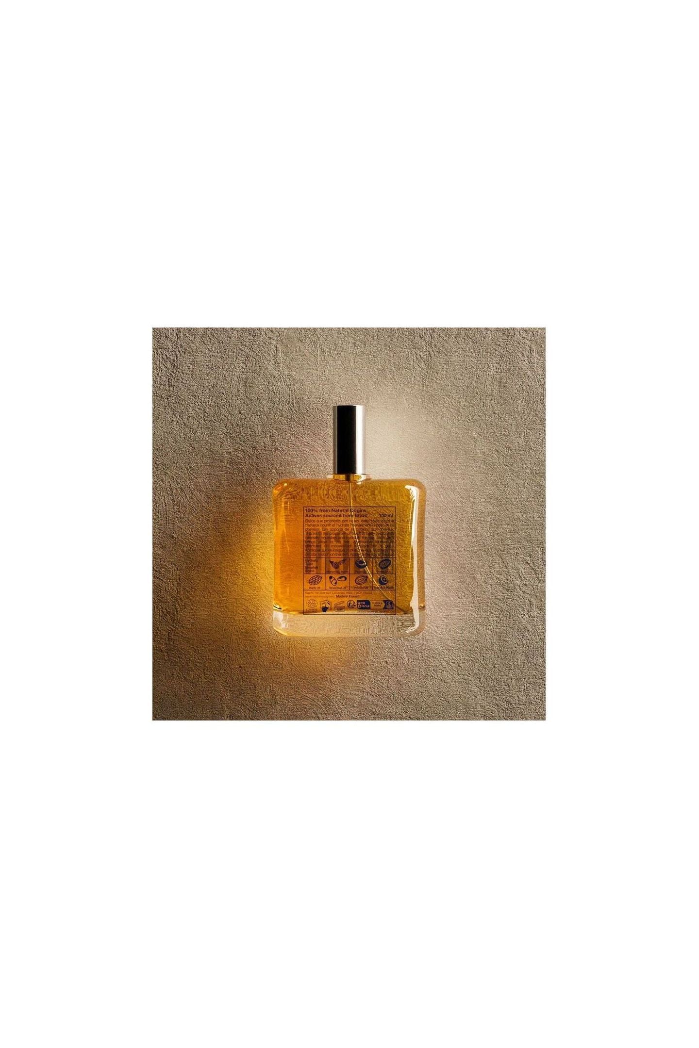 NATCHI Organic Hair & Body Oil in glass bottle, showcasing its golden color and organic certification.