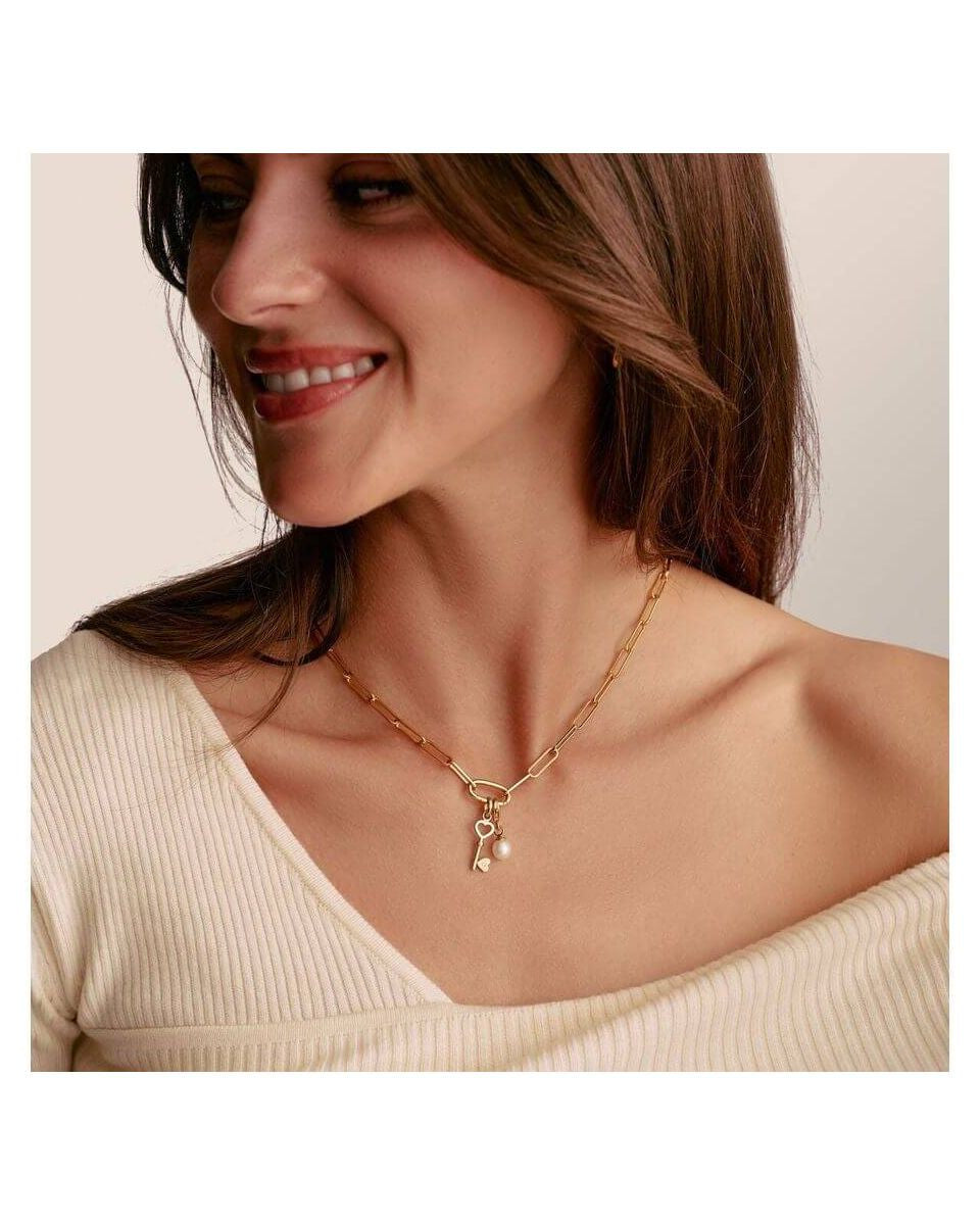 Femme souriante portant le collier Charm Paperclip en or avec Connect Link et breloques, élégant et raffiné.
