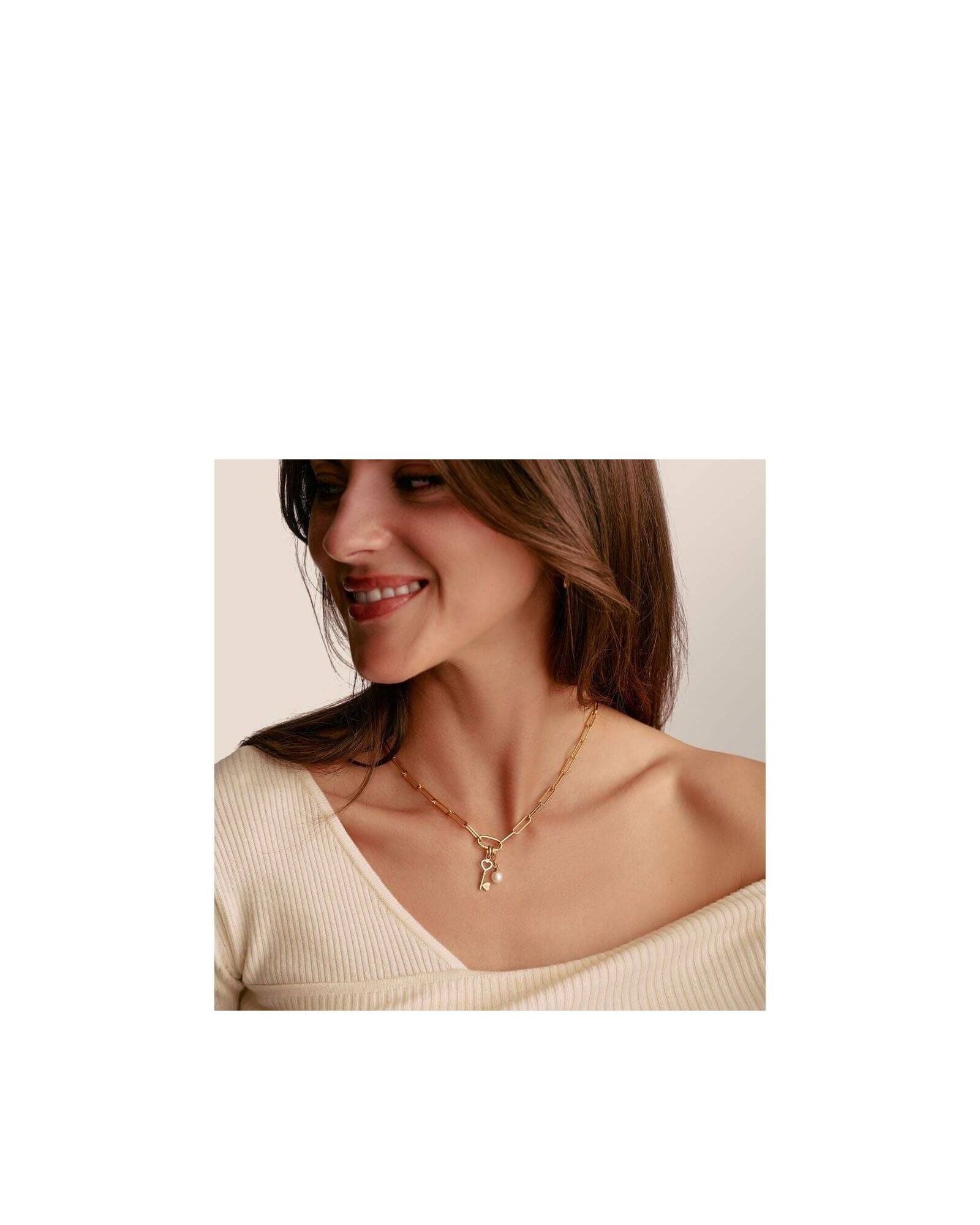 Femme souriante portant le collier Charm Paperclip en or avec Connect Link et breloques, élégant et raffiné.