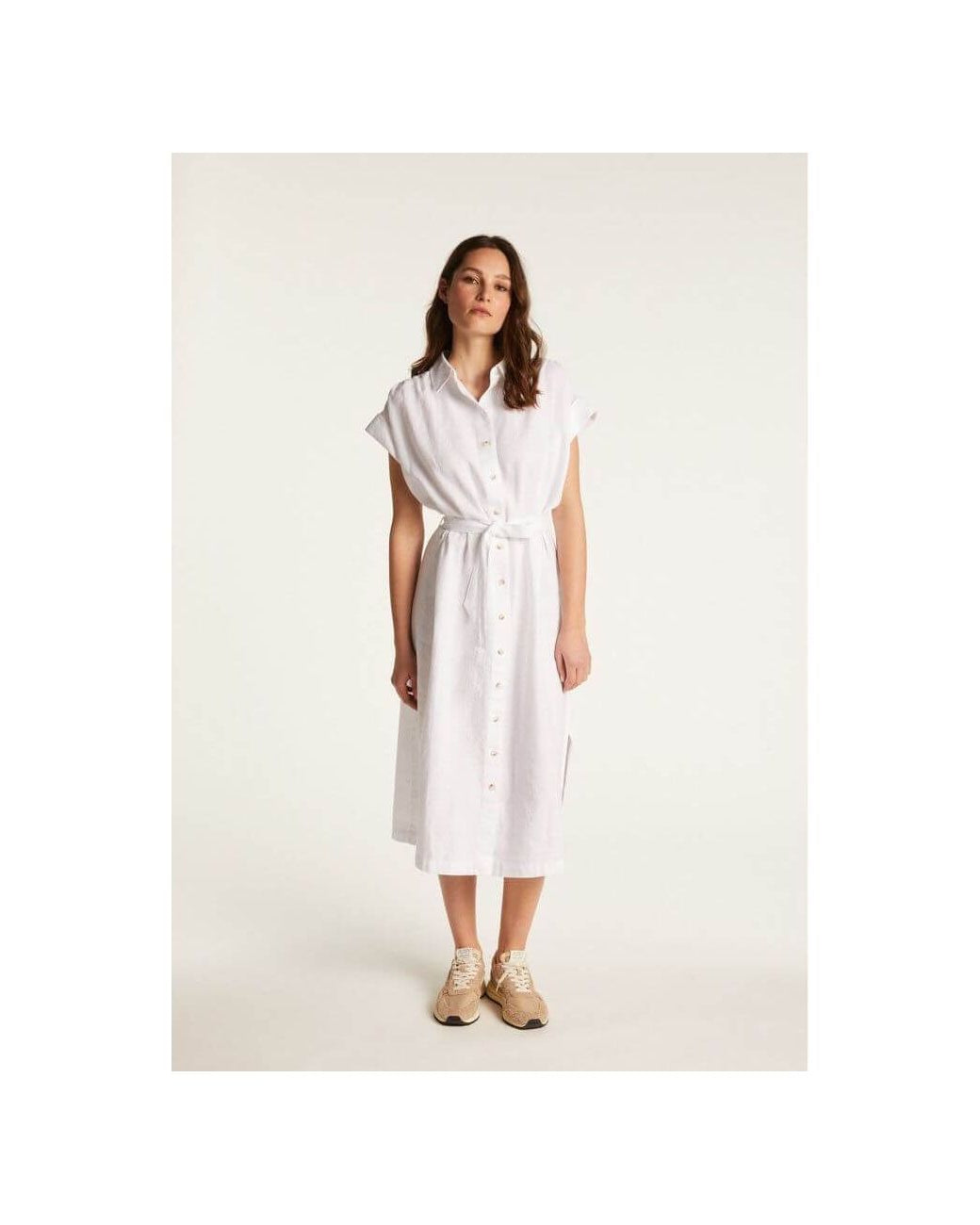 Femme portant la robe Emy en lin blanc, élégante et respirante, parfaite pour un look chic et décontracté.