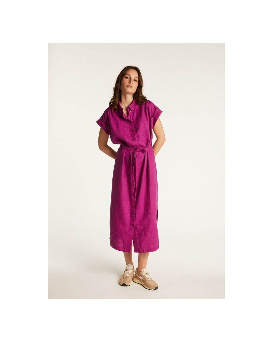 Femme portant la robe Emy, en lin léger, couleur fuchsia, offrant élégance et confort pour la saison.