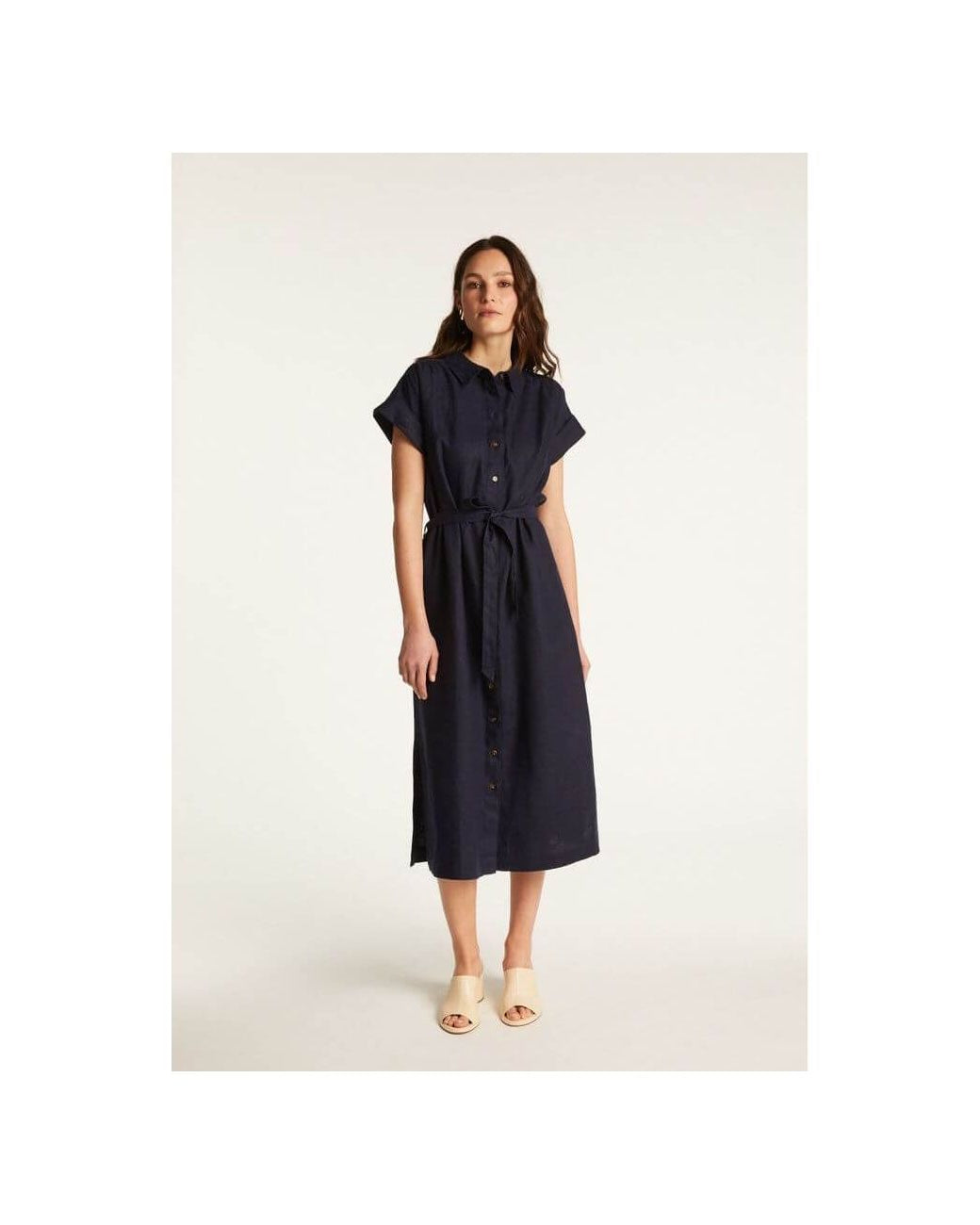 Femme portant la robe Emy, élégante et confortable, en lin léger, avec une coupe fluide et des manches courtes.