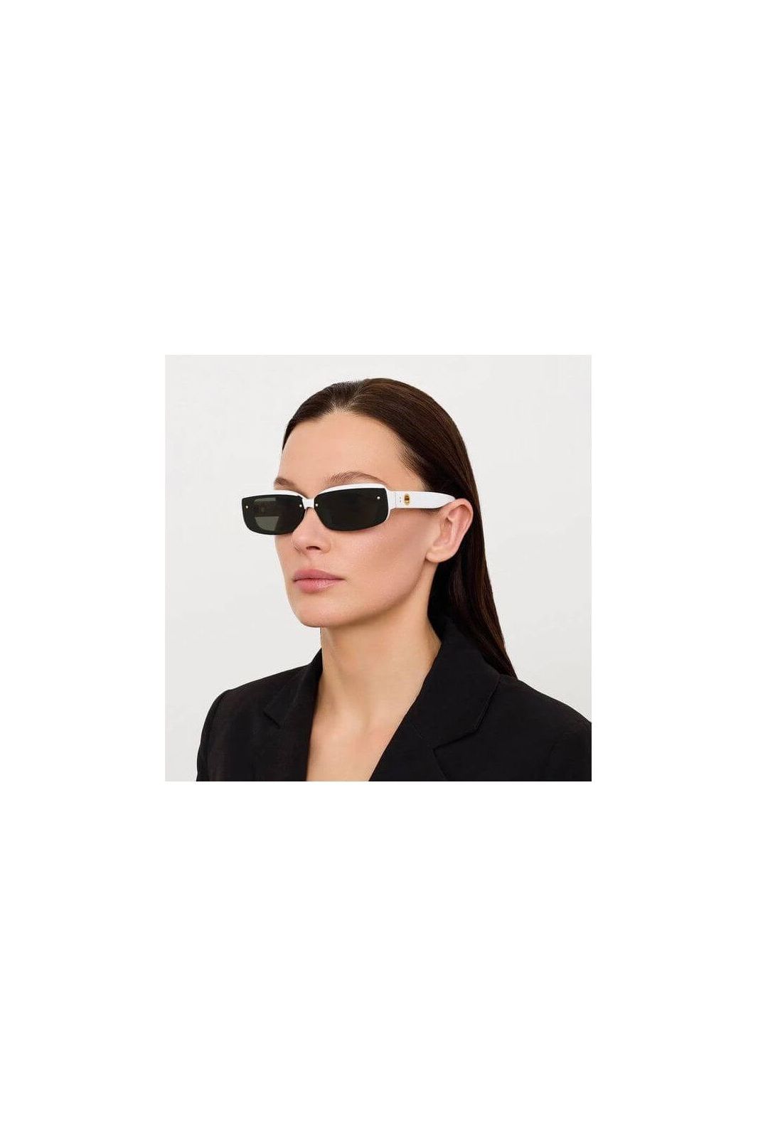 Lunettes de soleil Flick blanches avec verres noirs, offrant élégance et protection UV, portées par une femme.