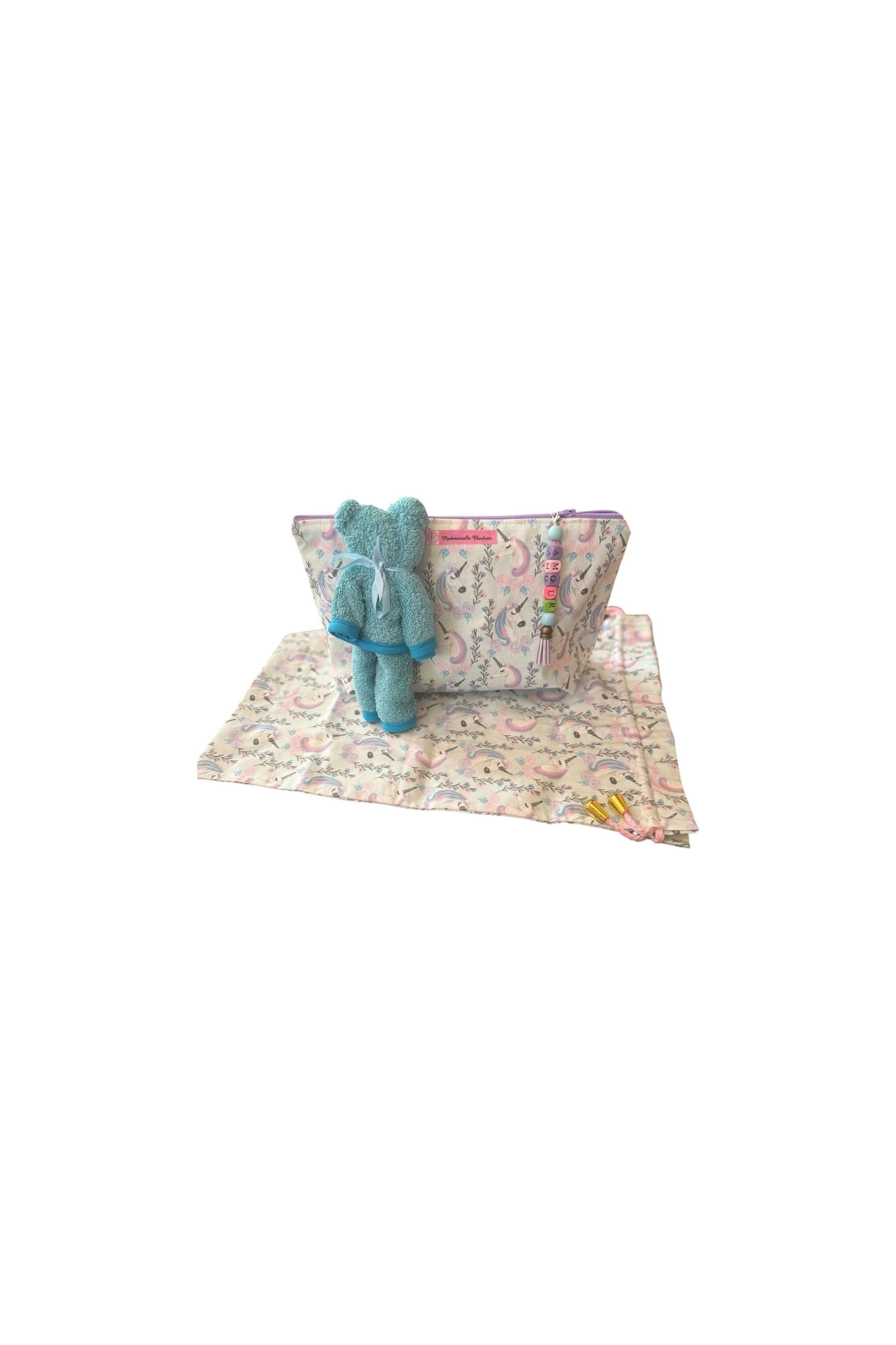 Pochette bébé en tissu avec doudou en peluche et tapis, pratique pour le change lors des déplacements.