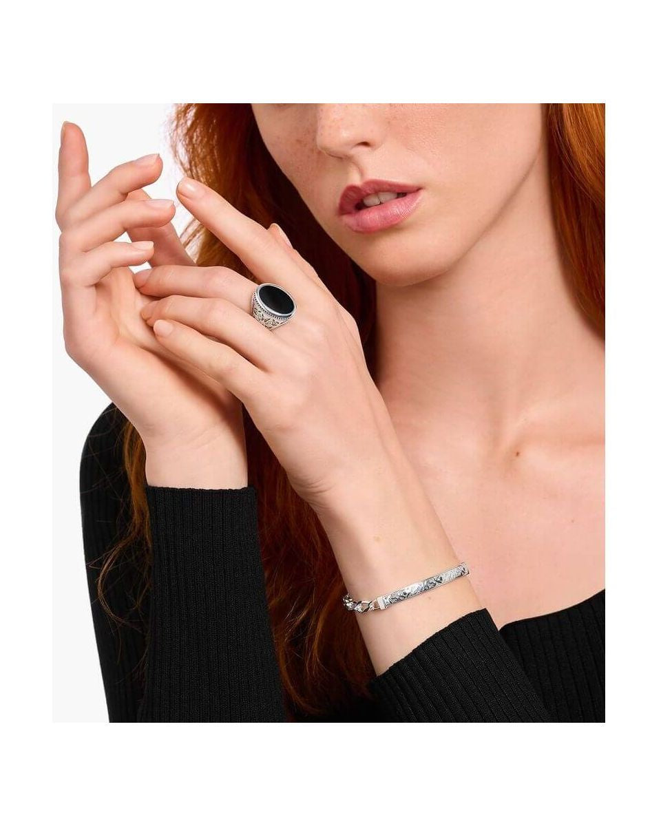 Femme portant une chevalière en argent noirci avec onyx noir et bracelet argenté.