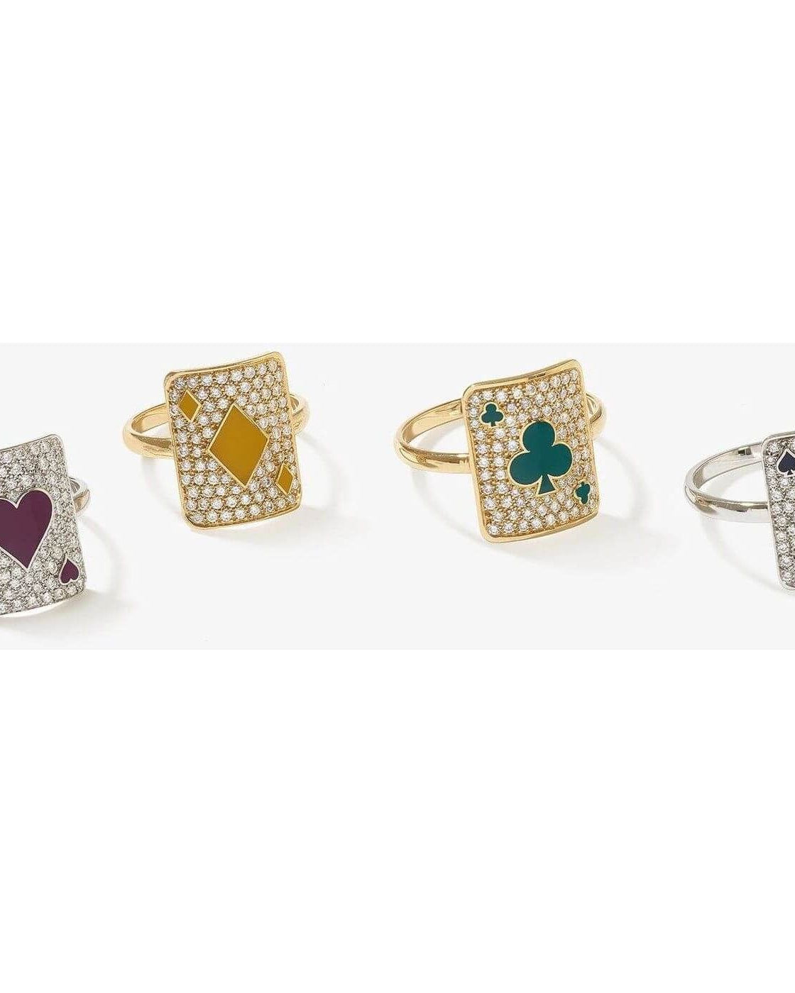 Set of four sparkling rings each featuring playing card designs with hearts, diamonds, clubs, and spades.