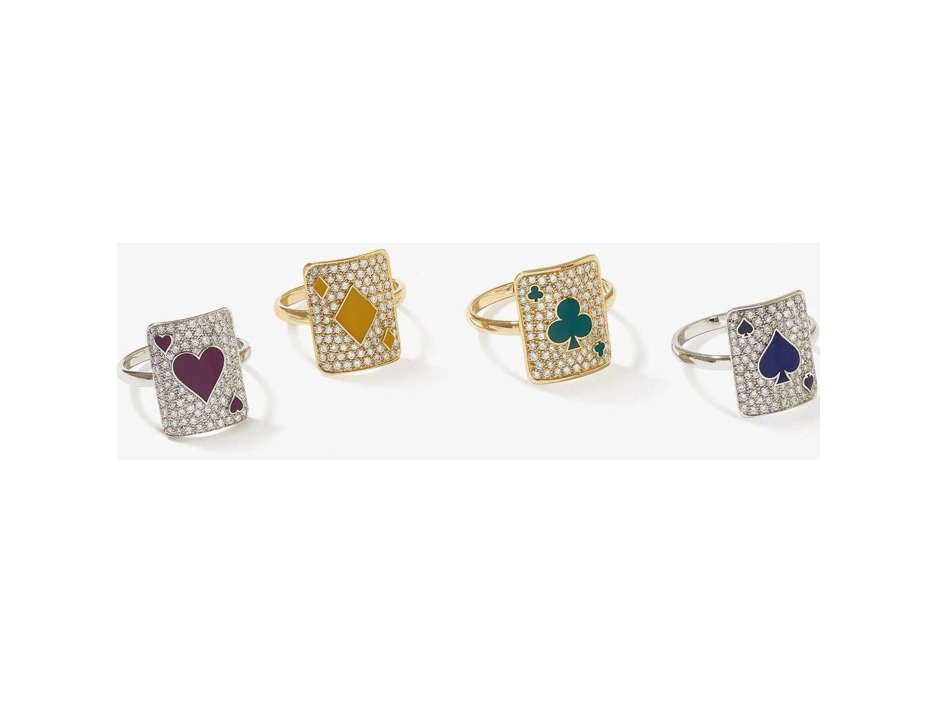 Set of four sparkling rings each featuring playing card designs with hearts, diamonds, clubs, and spades.