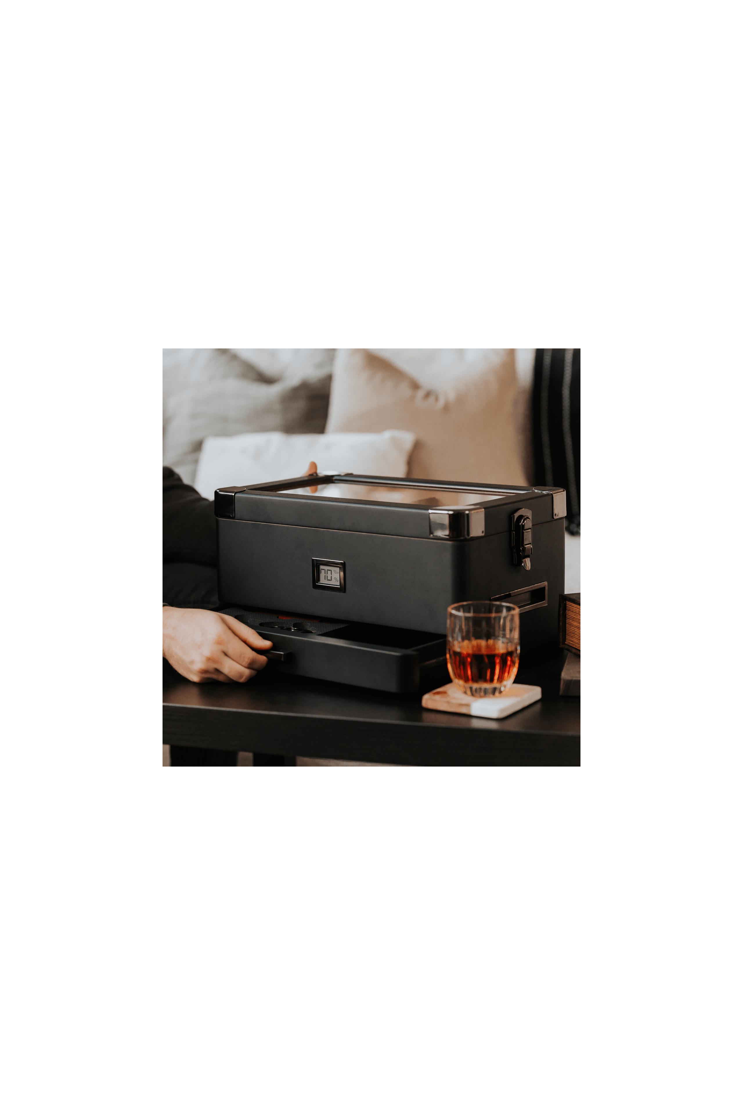 Humidor militaire Black Edition on a table with whiskey glass and modern design, showcasing its unique black matte finish.