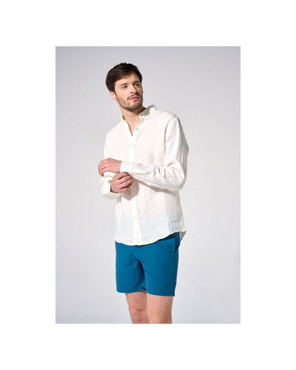 Homme en chemise en lin naturel blanc et short bleu, affichant une coupe classique et élégante.