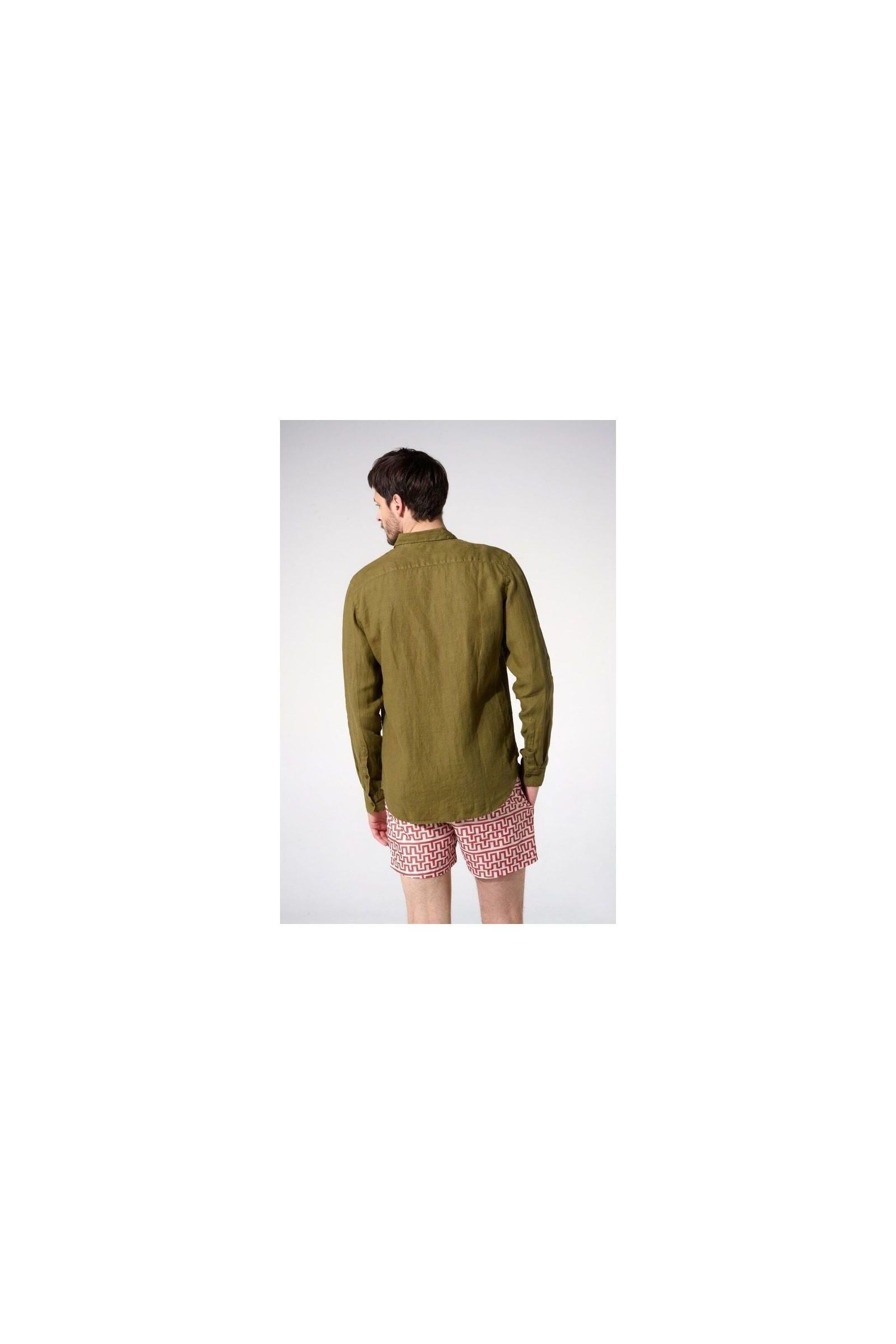 Homme portant une chemise en lin olive vue de dos, associée à un short à motifs.