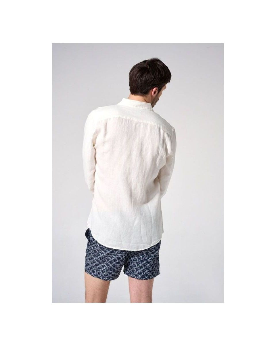 Homme portant une chemise en lin naturel européenne, vue de dos, avec des shorts à motifs, style décontracté.