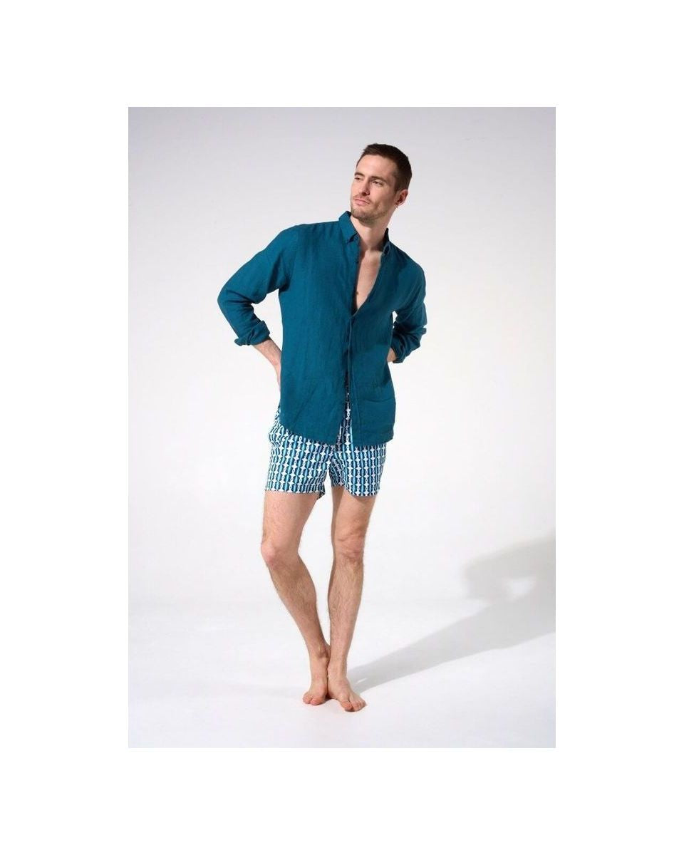 Homme portant une chemise en lin bleu avec un look décontracté, tenue estivale idéale.