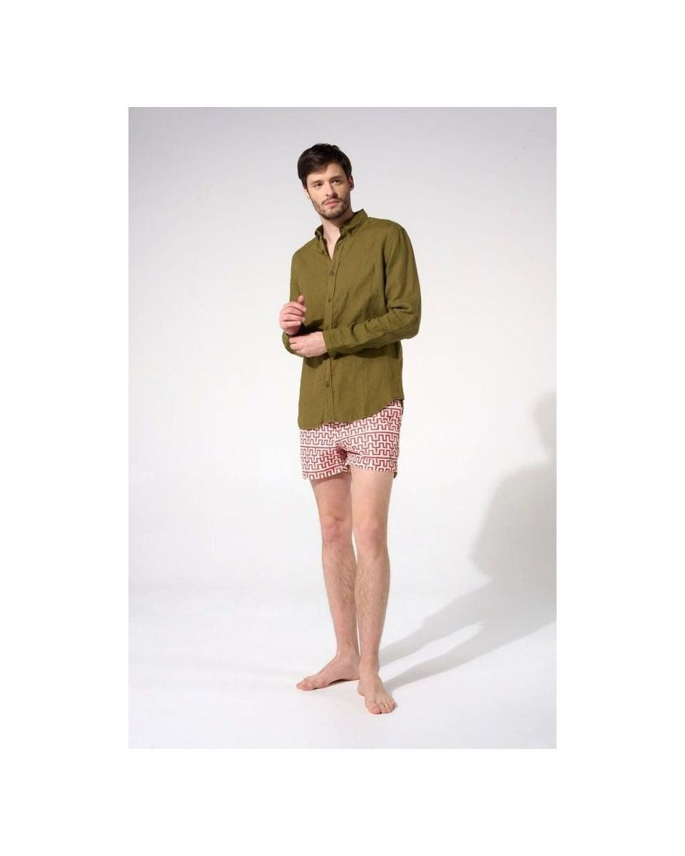 Homme portant une chemise en lin olive avec un pantalon court à motifs, montrant une coupe classique et décontractée.