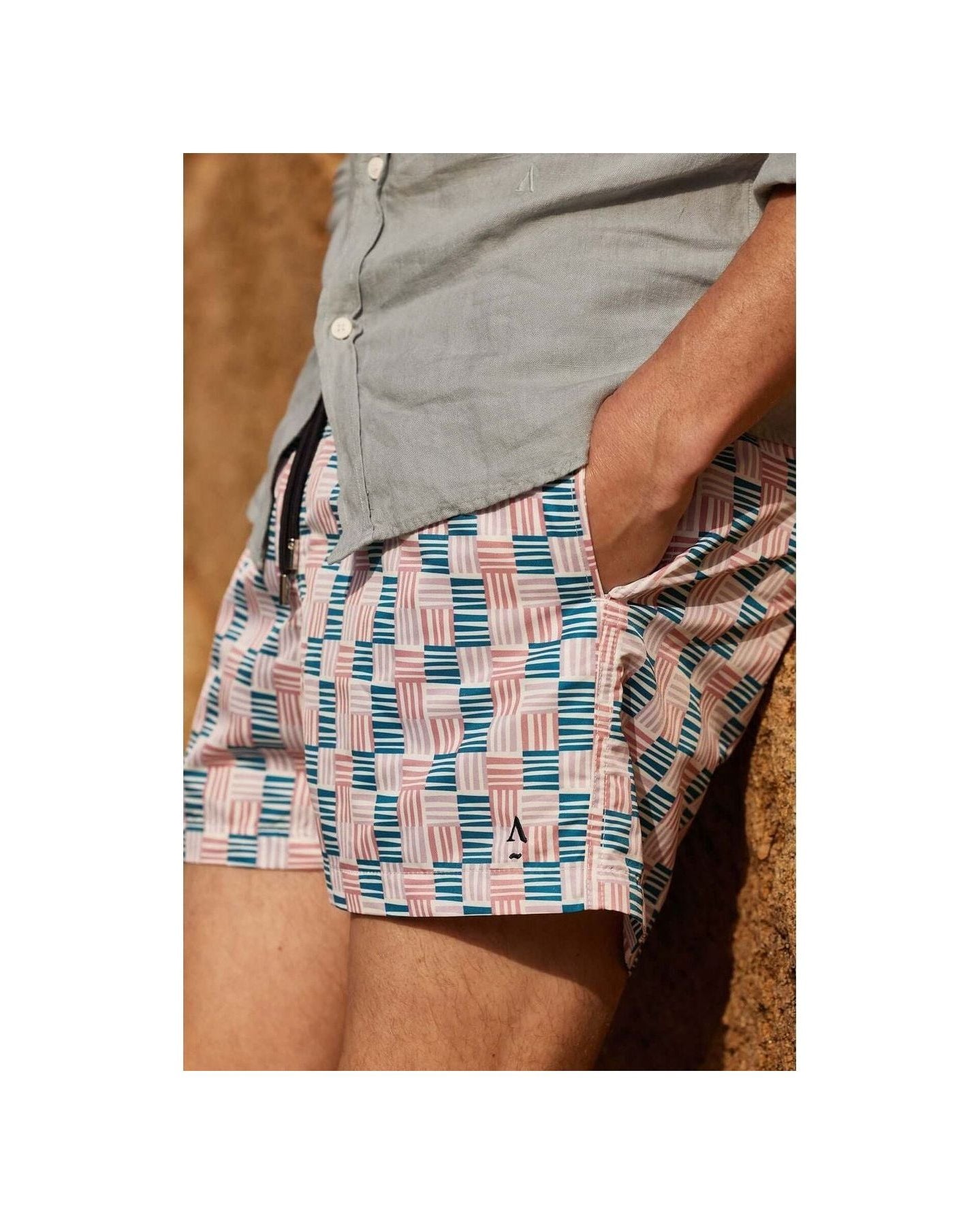Homme portant des shorts de bain Cannage avec motif géométrique, côté uni, et poche latérale.