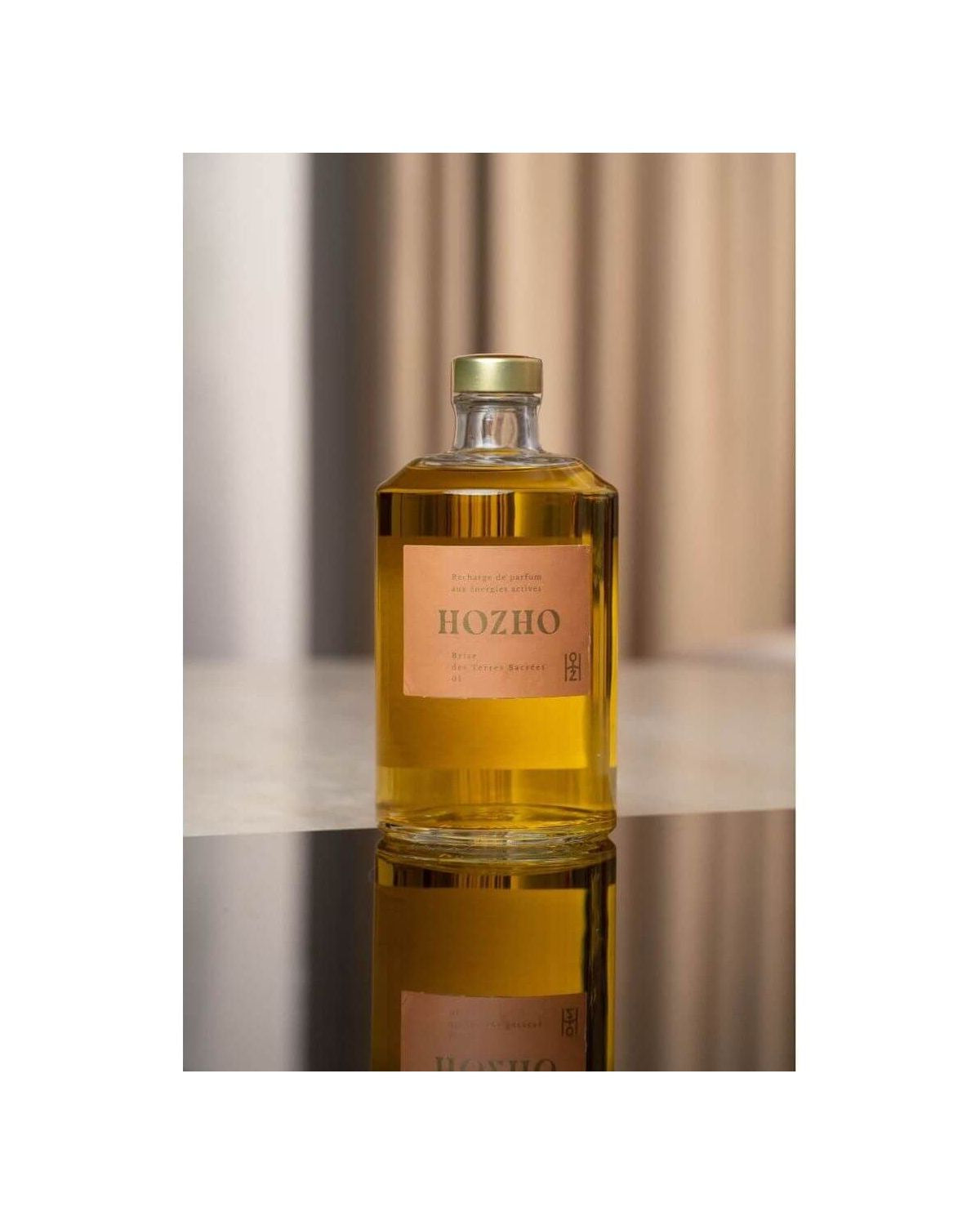 Bouteille de parfum Hozho sur une surface noire, reflétant un design élégant et moderne.