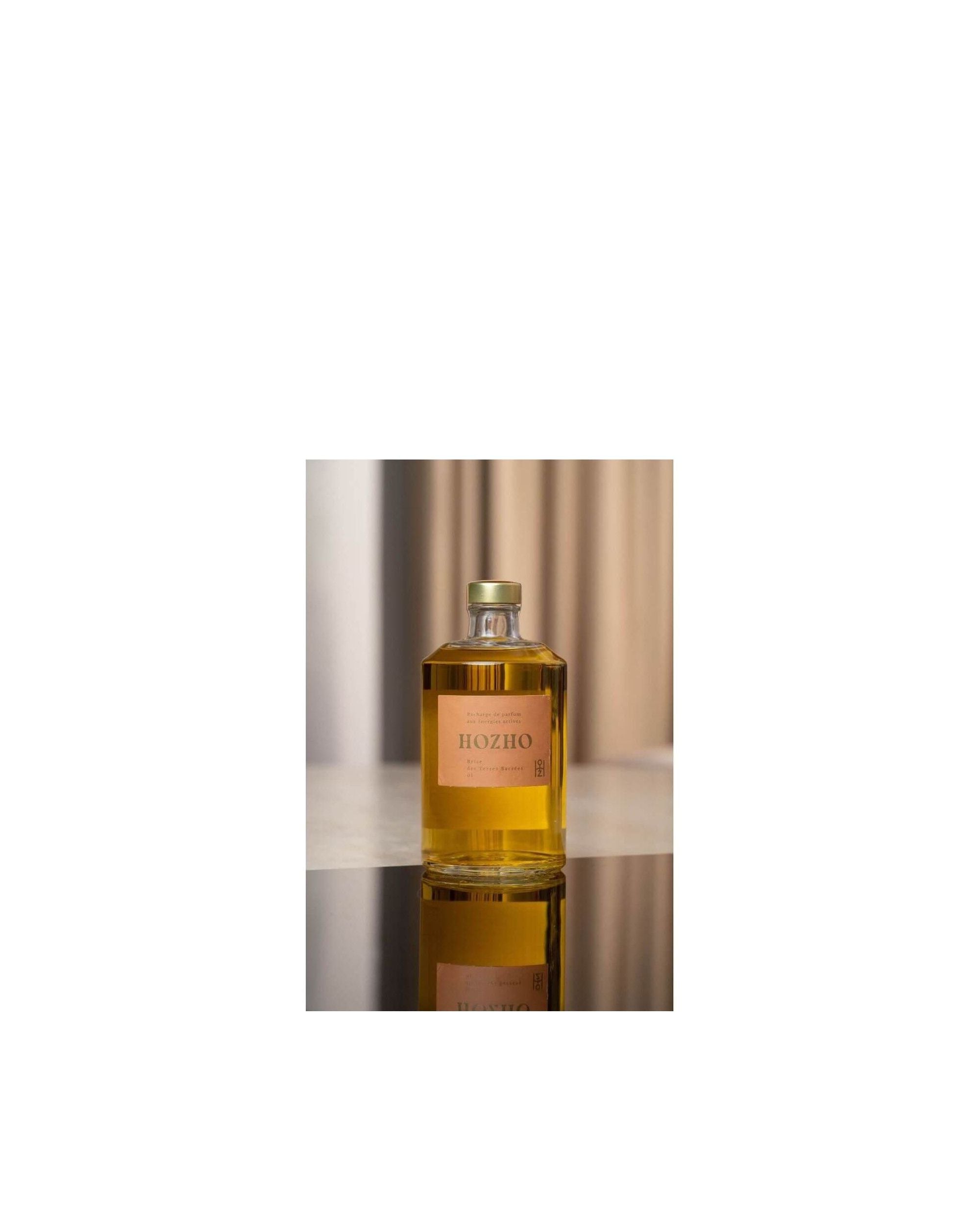 Bouteille de parfum Hozho sur une surface noire, reflétant un design élégant et moderne.