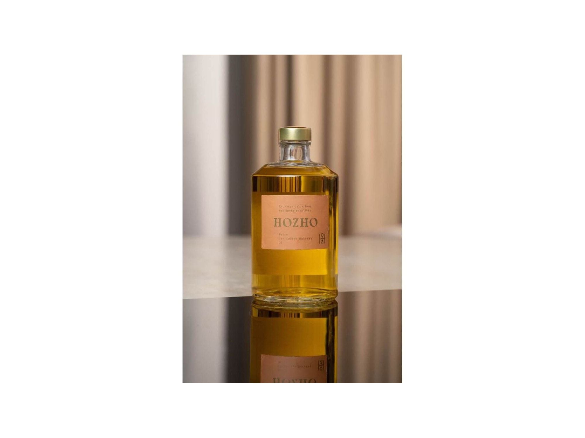 Bouteille de parfum Hozho sur une surface noire, reflétant un design élégant et moderne.