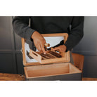 Person holding cigars in a unique black humidor, showcasing the craftsmanship and cedar wood inlay.