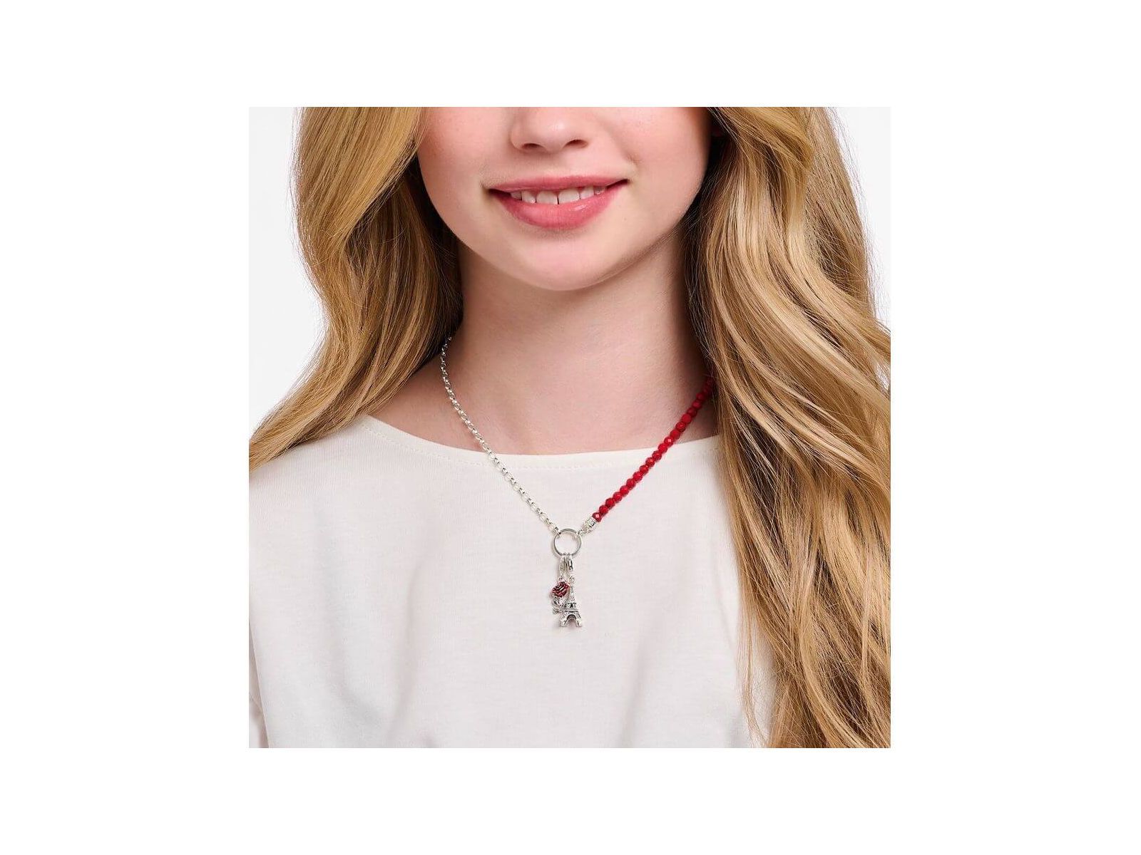 Femme portant un collier argenté avec un pendentif charm Tour Eiffel orné d'une zircone blanche.