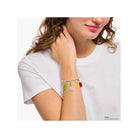 Bracelet charm with colorful gummy bear charms worn by a woman on her wrist, showcasing playful elegance.