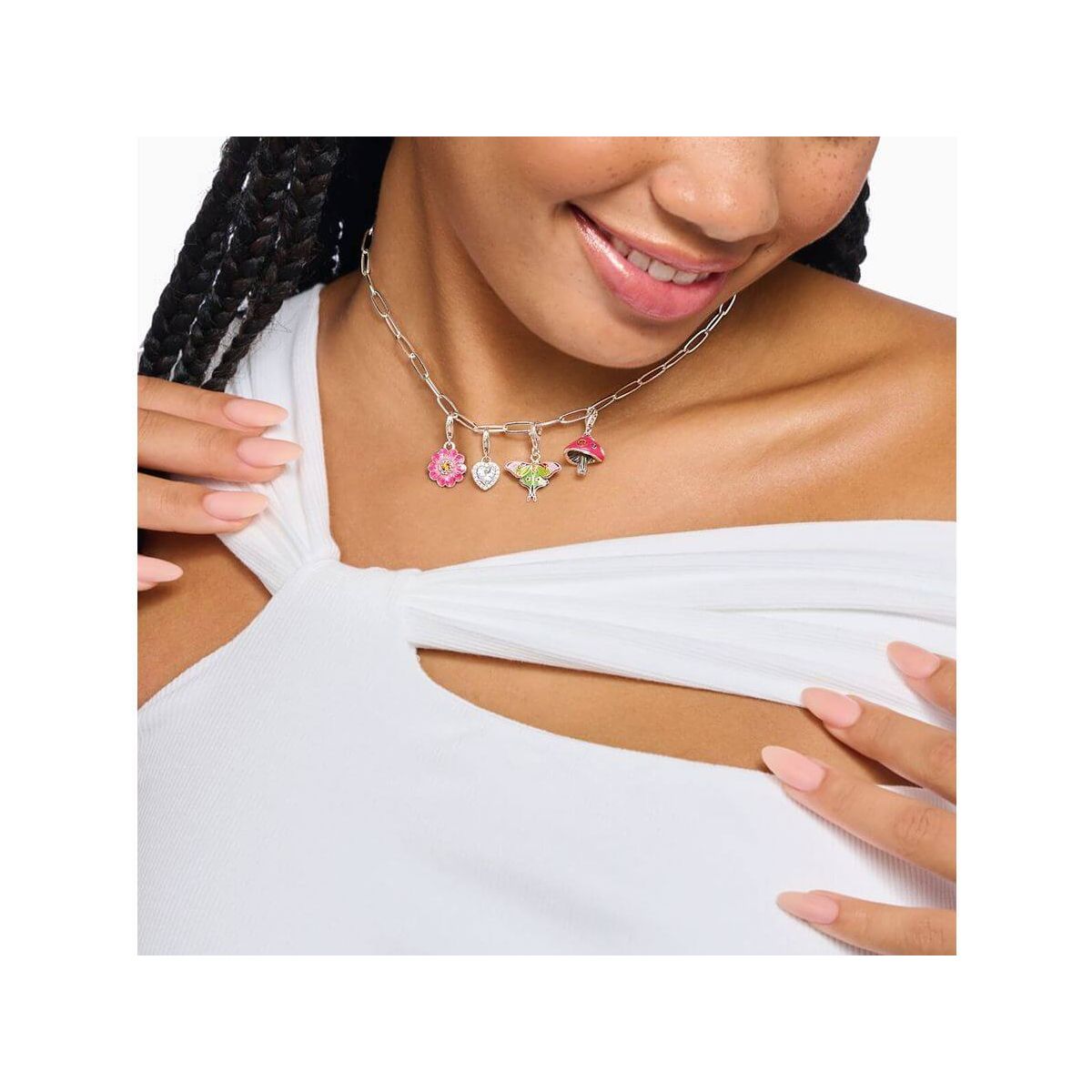Femme portant un collier charm avec pendentifs floraux colorés, ajoutant une touche élégante à sa tenue.