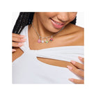 Femme portant un collier charm avec pendentifs floraux colorés, ajoutant une touche élégante à sa tenue.