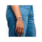 Bracelet with pink charm on woman's wrist, featuring beads and floral design, perfect for Charm Club jewelry.