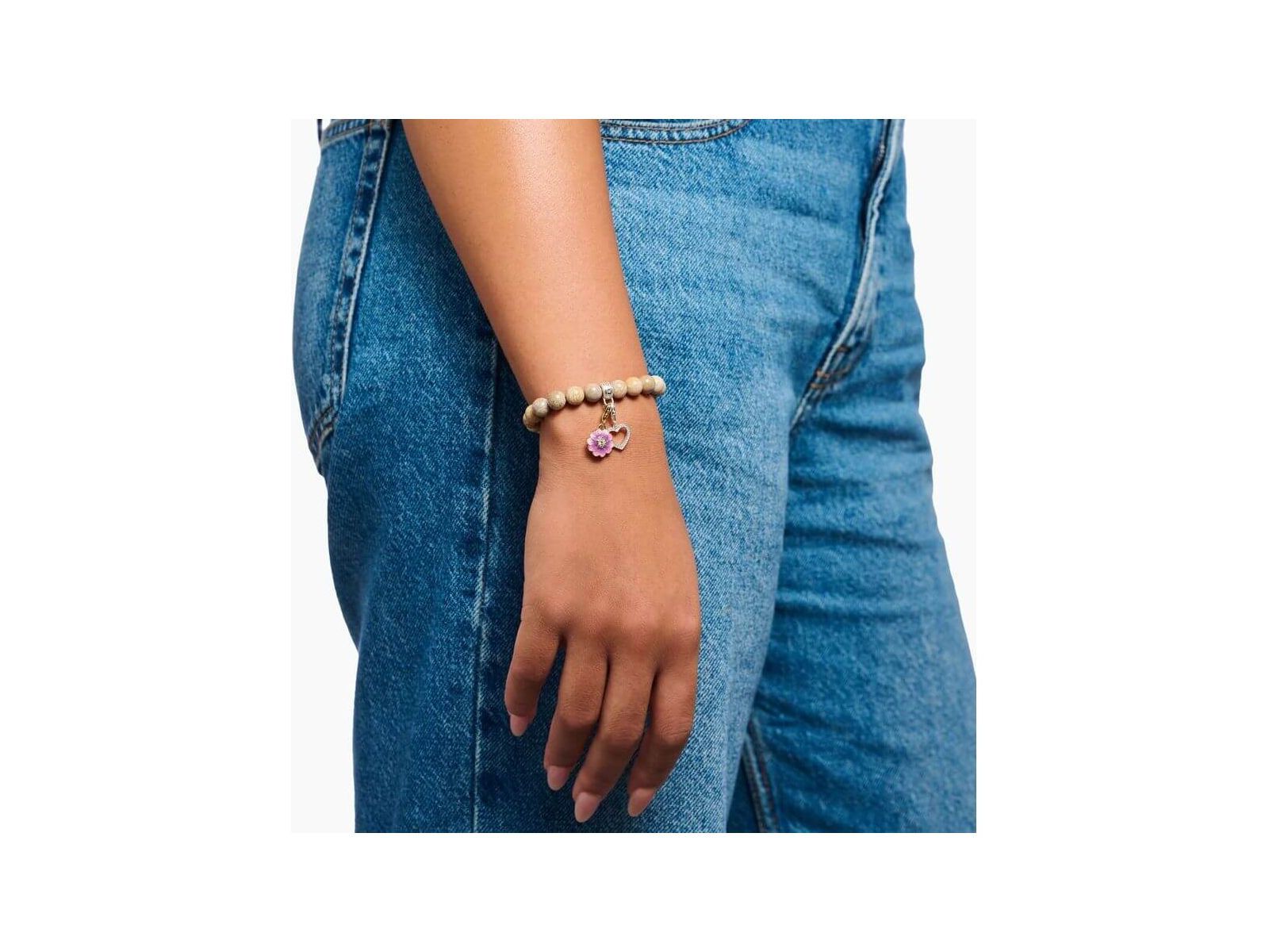 Bracelet with pink charm on woman's wrist, featuring beads and floral design, perfect for Charm Club jewelry.