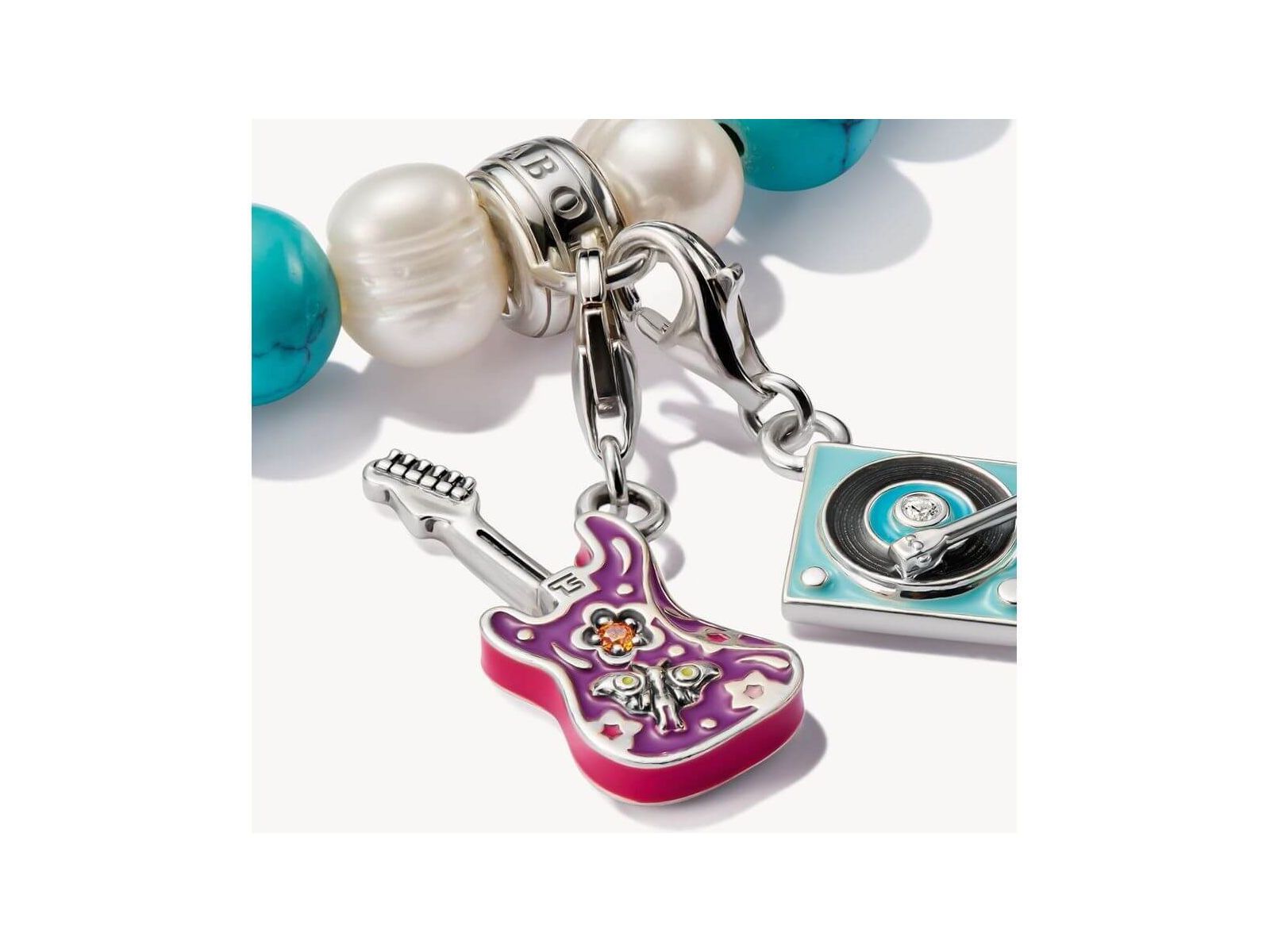Pendentif charm guitare électrique en argent avec détails floraux et émail coloré.