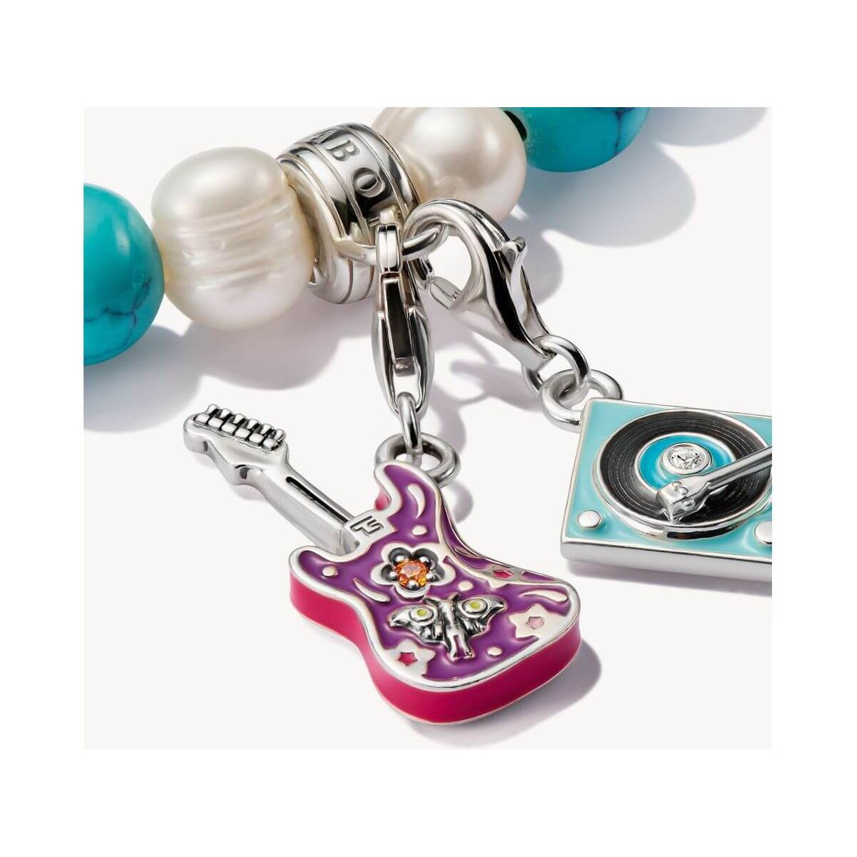Pendentif charm guitare électrique en argent avec détails floraux et émail coloré.