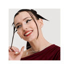 Model showcasing HARIBO silver bear earrings, smiling and wearing layered necklaces in a stylish outfit.