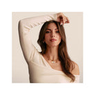 Modèle présentant un pendentif charm en or avec pierres blanches, dégageant élégance et style unique.