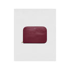 La Pochette Claude, burgundy 13-inch laptop sleeve, premium PVC exterior, cotton lining, gold zipper closure.