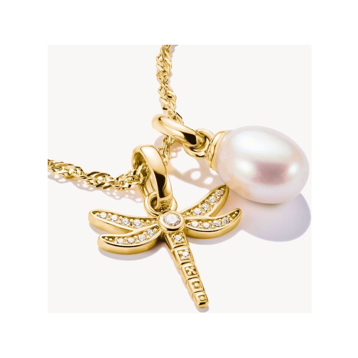 Pendentif charm libellule plaqué or avec pierres blanches et perle, élégant bijou nature.